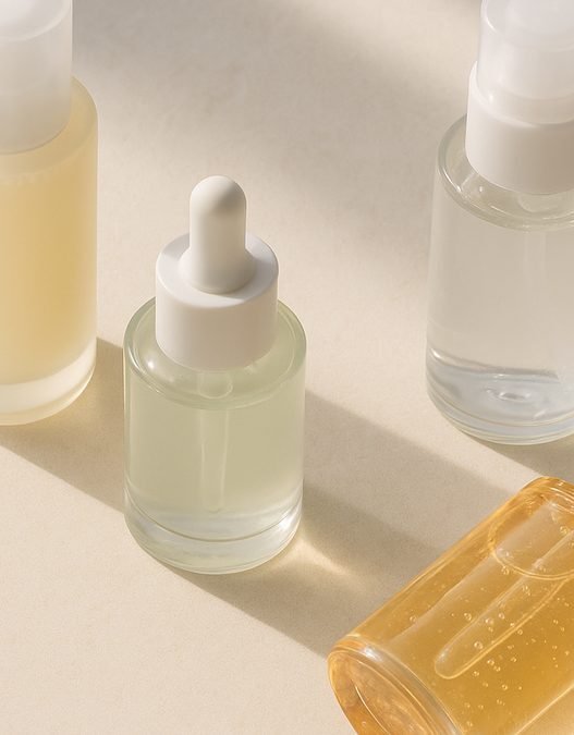 A flatlay of Korean beauty skincare products including essence, serum and sunscreen bottles on a soft background