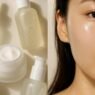 A flatlay of Korean skincare products including a milky toner and facial mist arranged on a soft surface