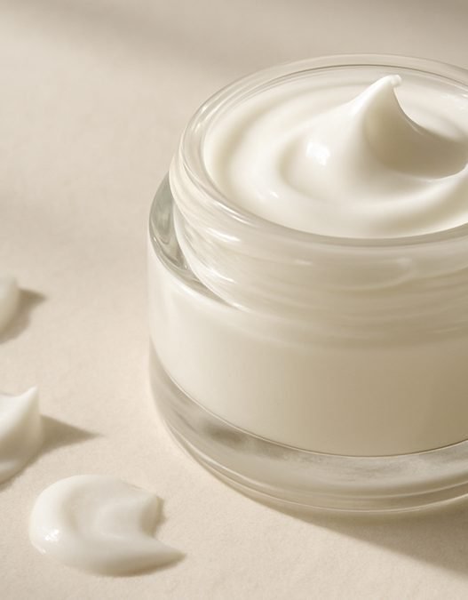 A clear gel-cream PDRN moisturiser swatched beside a skincare tube on a neutral background
