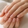 Close-up of hands with a fresh gel manicure at a nail salon